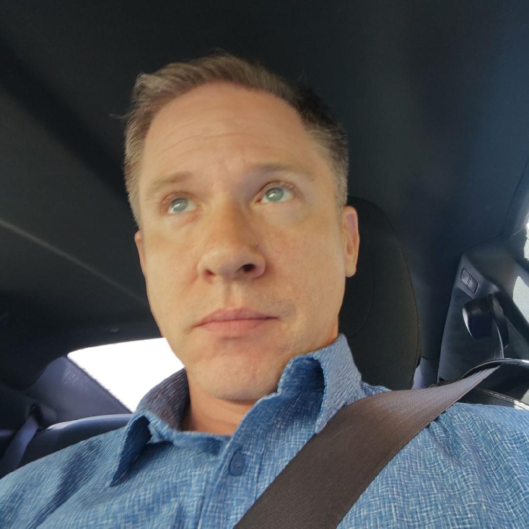 Joshua in a blue shirt seated in a car